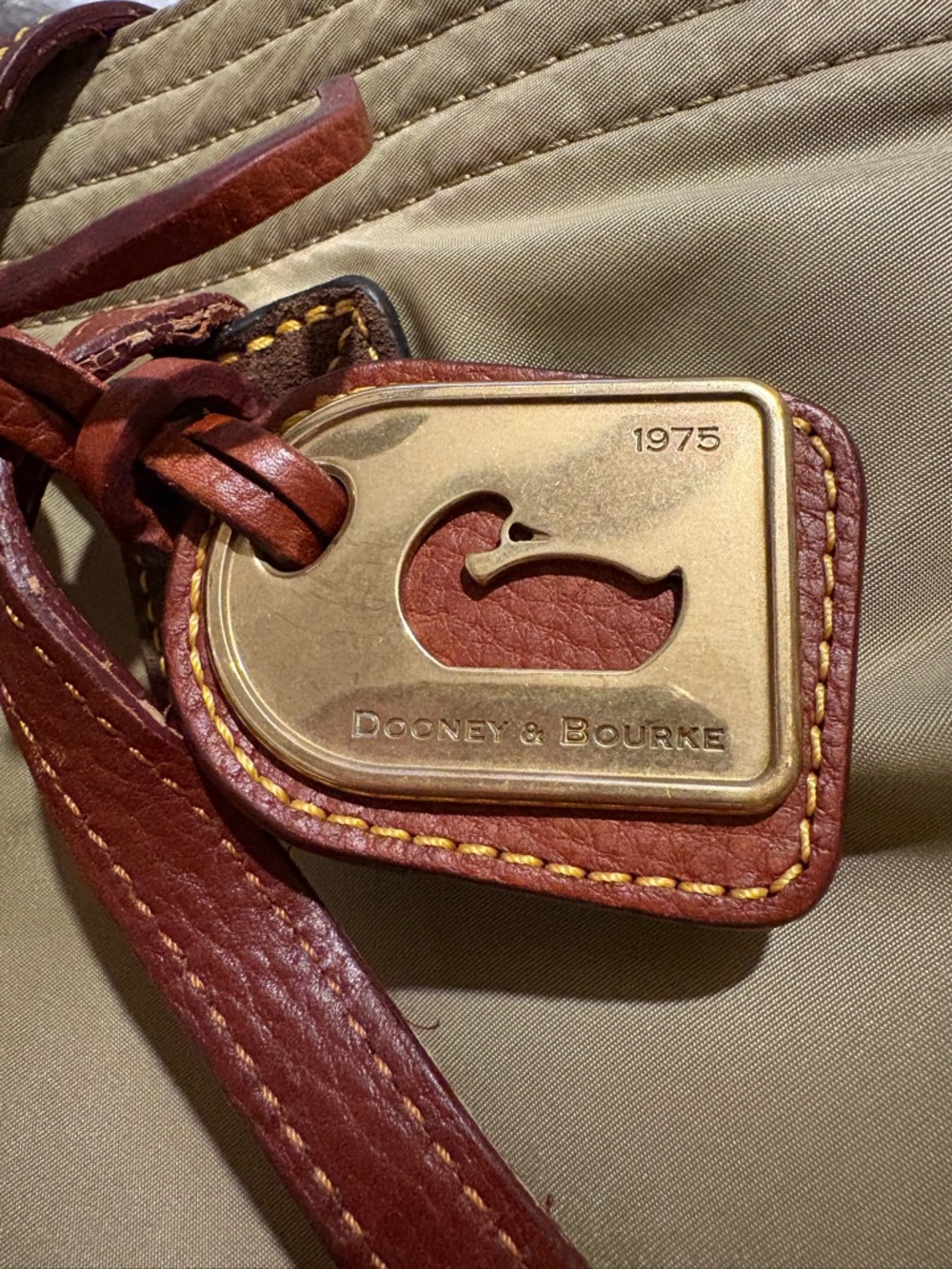 Dooney & Bourke Tan Canvas purse with Brown Leather Trim and Brass Tag
